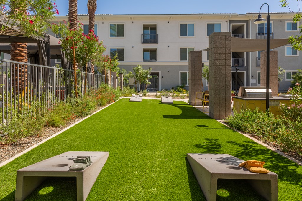 A grassy area with two concrete benches in front of a building.
