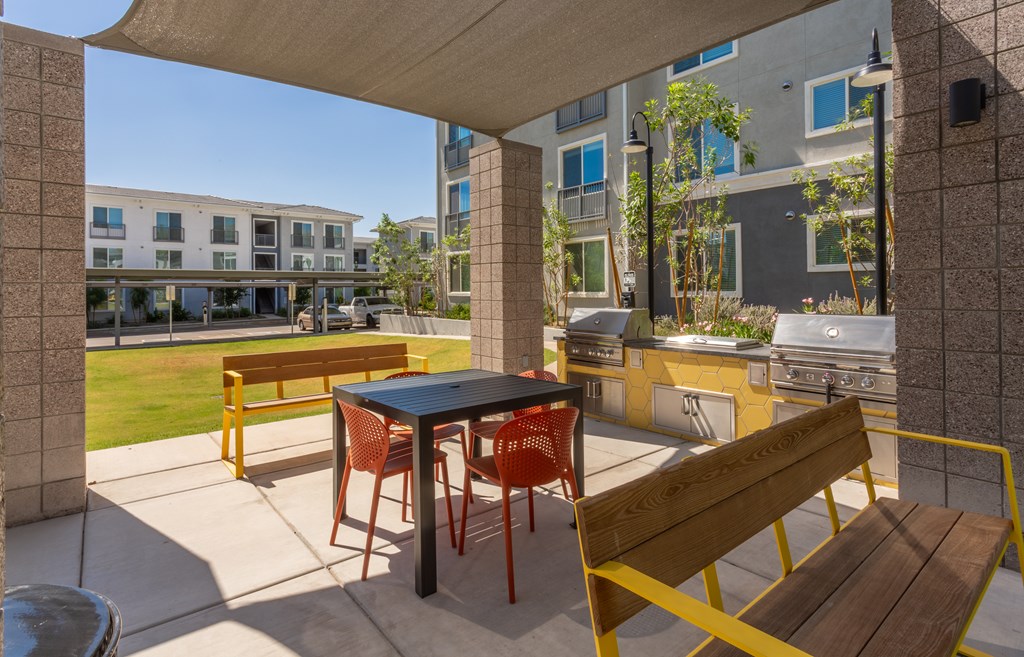 A patio with a table and chairs is covered by a roof.