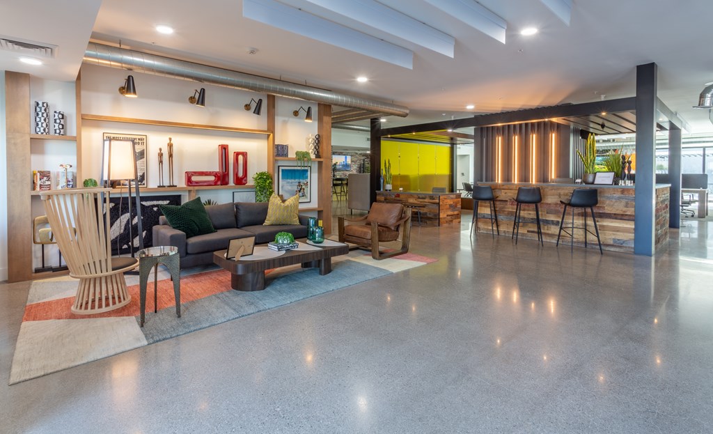 A modern living room with a grey floor and a variety of furniture.