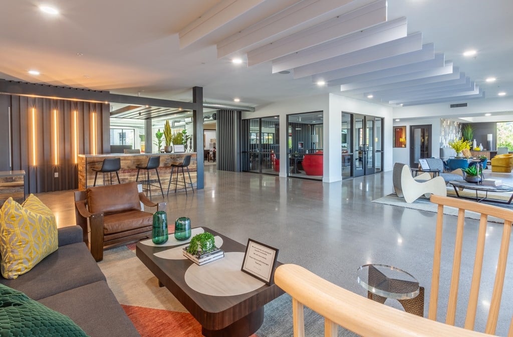 A modern living room with a variety of seating options and a coffee table.