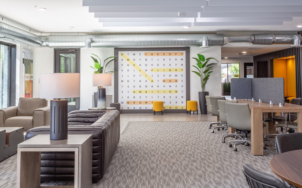 A modern office space with a large calendar on the wall and a variety of seating options.