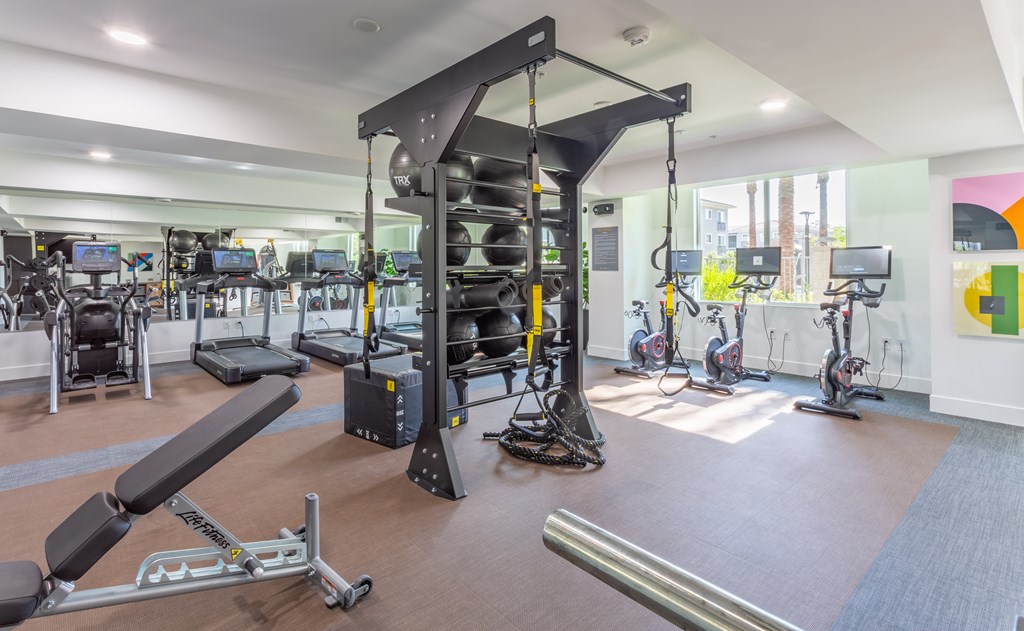A gym with a variety of equipment including a leg press machine.