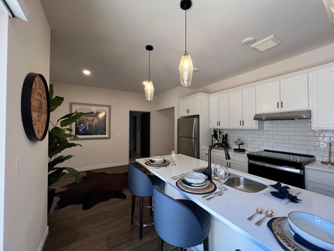 an open kitchen and dining area with a white counter top