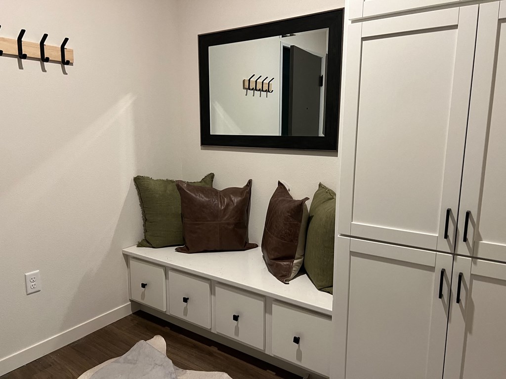 a bench with pillows in a room with a mirror