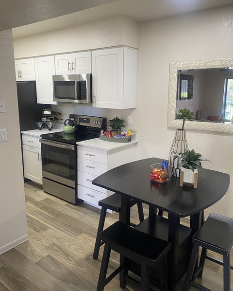 A black table with two chairs in a kitchen.