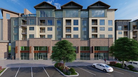 A modern apartment building with a parking lot in front.