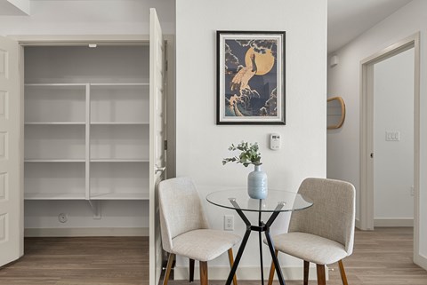 Dining area with glass table and builtin shelving at Lucero Apartments, Phoenix