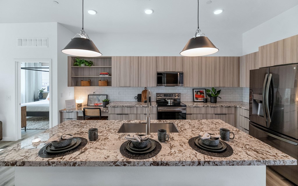 A kitchen with a granite countertop and stainless steel appliances.at Marketside Villas at Verrado, Buckeye, 85396