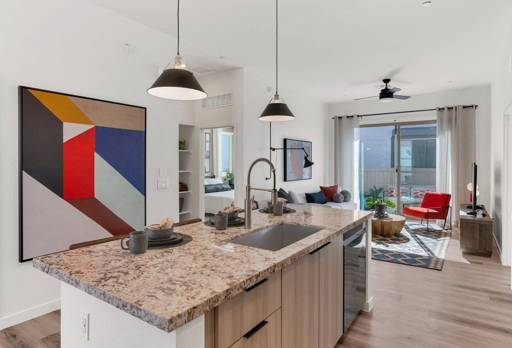 A modern kitchen with a granite countertop and a large abstract painting above it.at Marketside Villas at Verrado, Buckeye, AZ, 85396