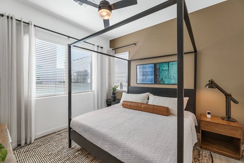 A bedroom with a four poster bed and a ceiling fan.at Marketside Villas at Verrado, Buckeye, AZ