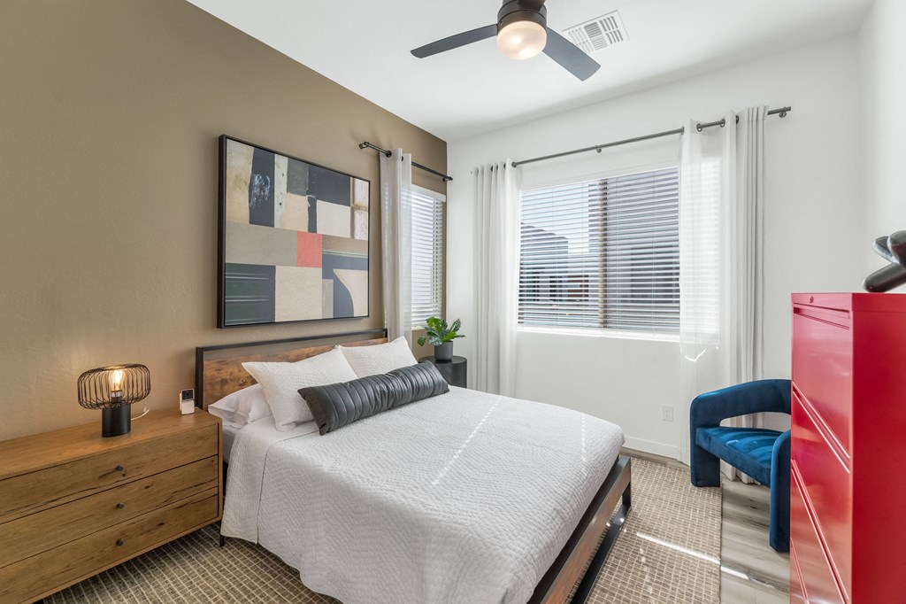 A bedroom with a bed, a chair, and a painting on the wall.at Marketside Villas at Verrado, Arizona, 85396