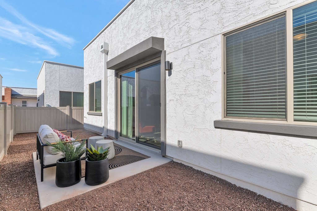 A white house with a patio and a chair.at Marketside Villas at Verrado, Arizona, 85396