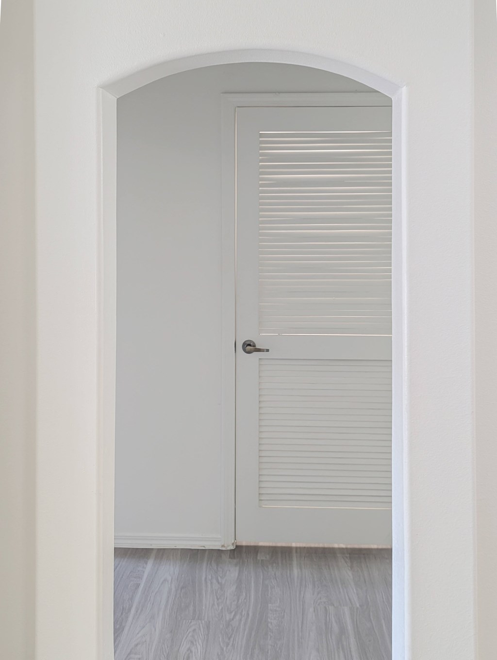 A white door with a silver handle is closed.