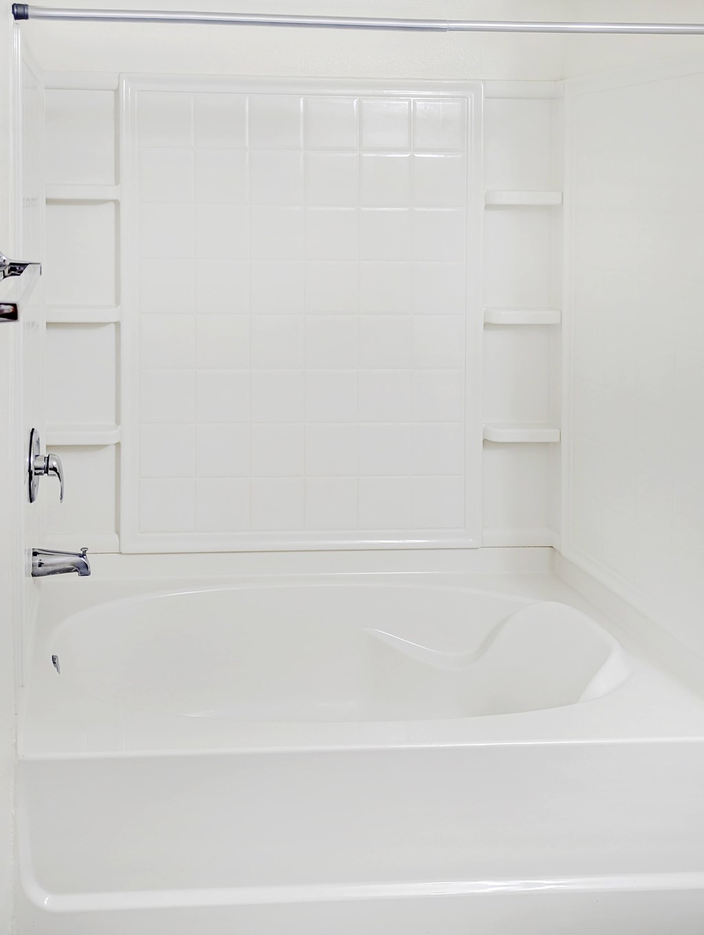 A white bathtub in a bathroom with a white door.