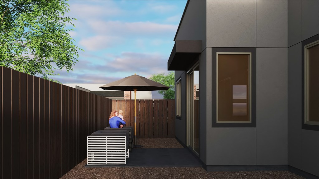 a rendering of a house with a woman sitting on a bench under an umbrella at Marketside Villas at Verrado, Buckeye