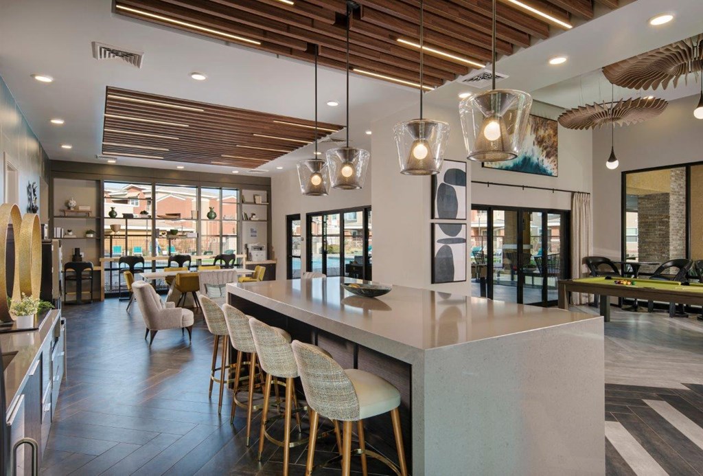 a large kitchen with a long island with a bunch of chairs in front of it at Zaterra Luxury Apartments, Chandler, AZ, 85286