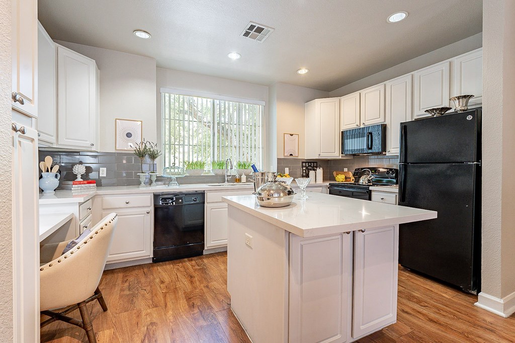 A kitchen with black appliances and white cabinets.at Palazzo Townhomes, Phoenix, AZ 85008  