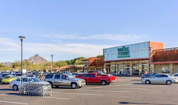 a parking lot filled with cars in front of a shopping center