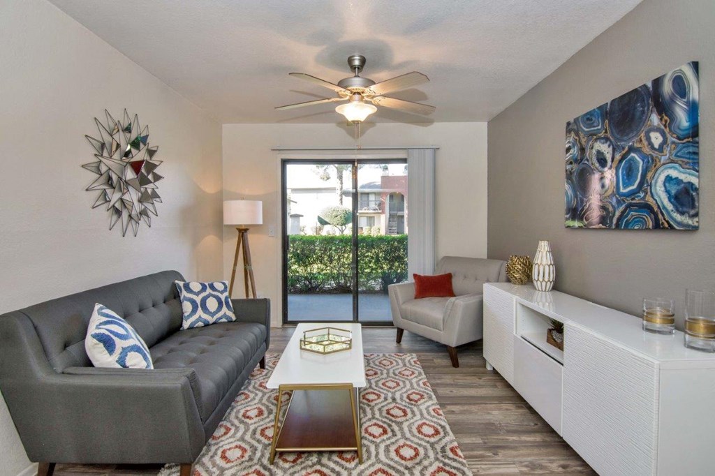 a living room with a couch and a ceiling fan
