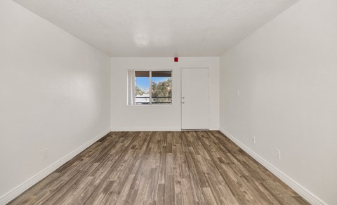 A room with a white door and a window with a view of trees and a house at Urban WalkApartments on 6th Avenue, Phoenix, AZ