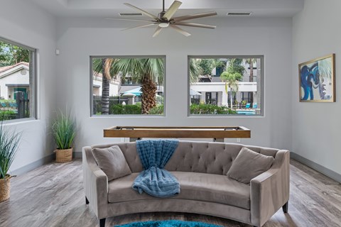 A living room with a couch and a ceiling fan.