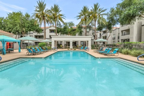 A large swimming pool in the middle of a resort area.