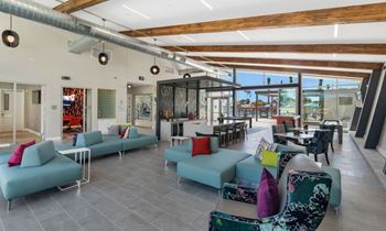 a lounge area with blue couches and colorful pillows at Melody on Main, Mesa, 85210