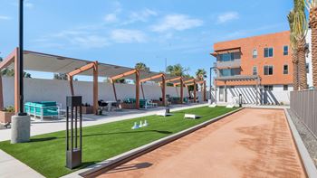 a grassy area with picnic tables and chairs in front of a building at Melody on Main, Mesa