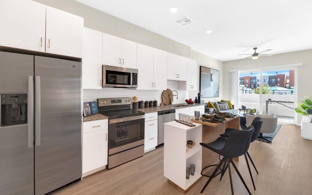 a kitchen with white cabinetry and stainless steel appliances at Melody on Main, Mesa