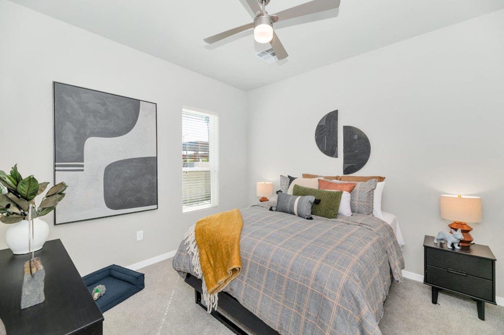 a bedroom with a bed and two windows at Melody on Main, Mesa, 85210