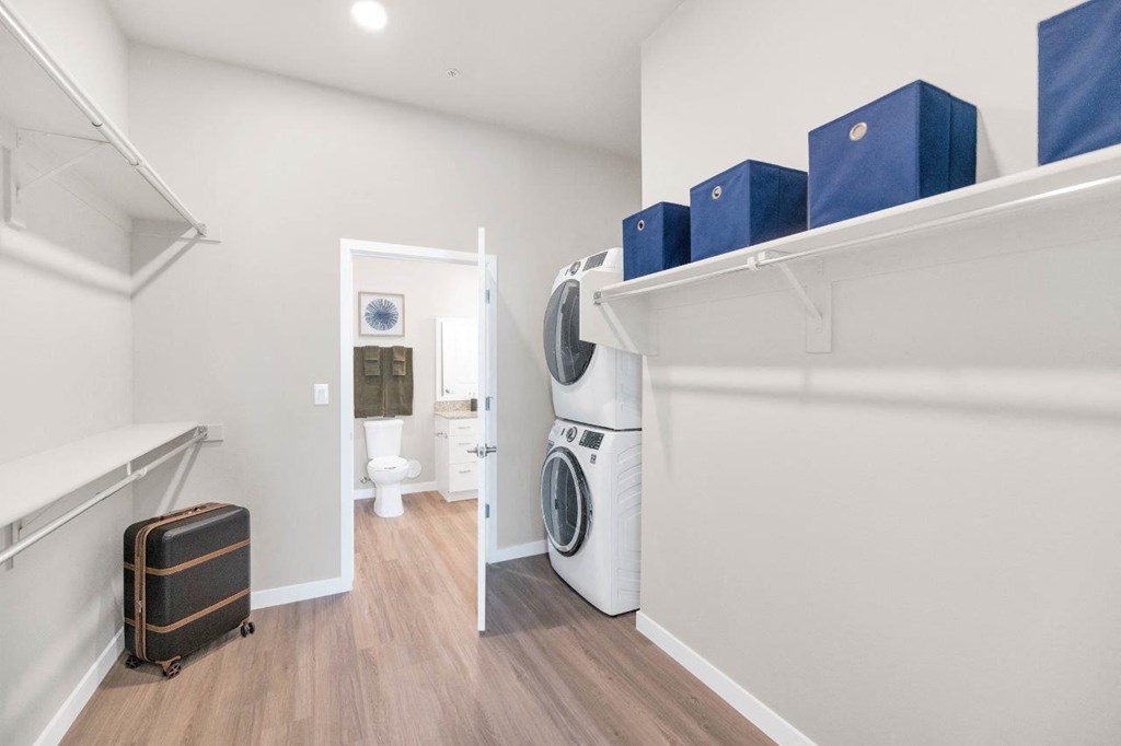 a washer and dryer in a laundry room with a bathroom in the background  at Melody on Main, Mesa, AZ, 85210