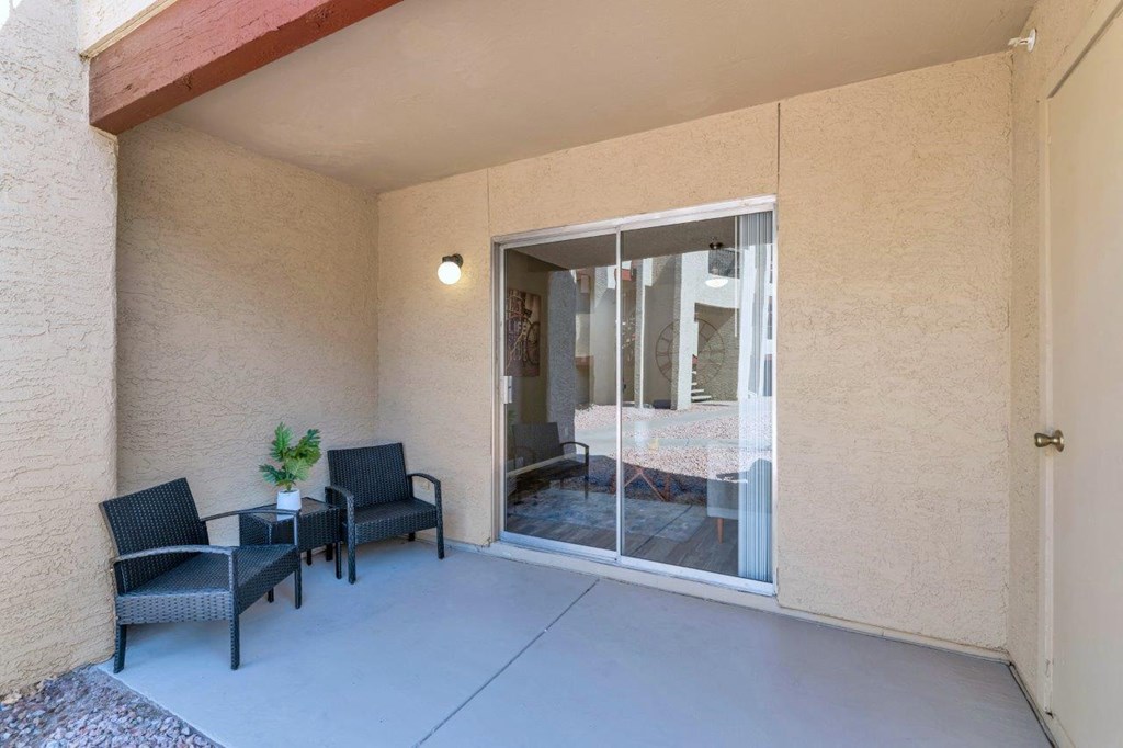 a patio with chairs and a sliding glass door  at Glen Brae, Glendale, AZ, 85301