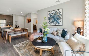 a living room with a couch and a table with a vase with flowers on it