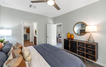 a bedroom with a bed and a dresser in front of it