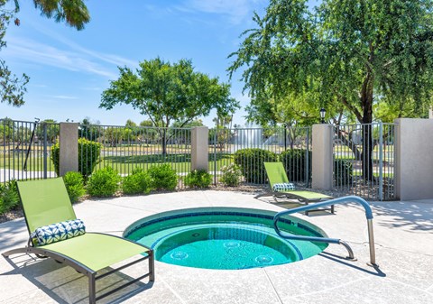 A pool with a green chair and a pillow beside it.