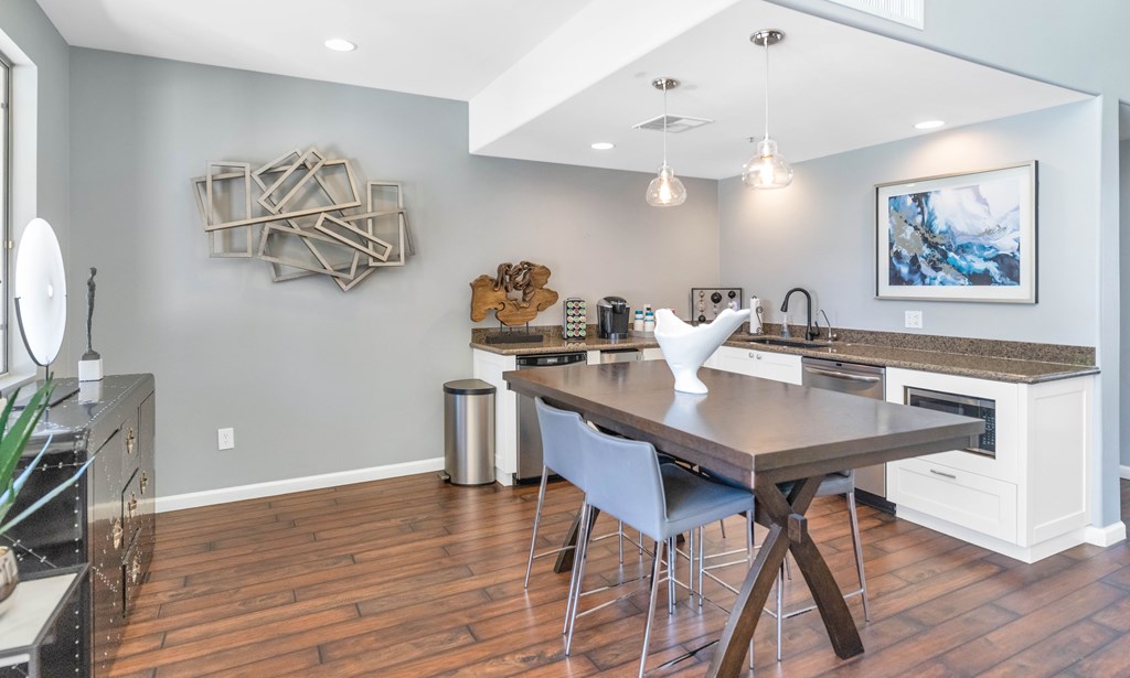 A modern kitchen with a wooden table and chairs.