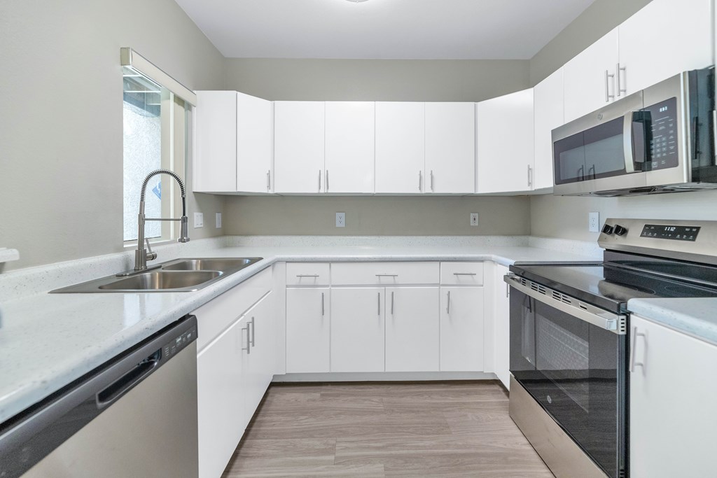 A kitchen with white cabinets and stainless steel appliances.