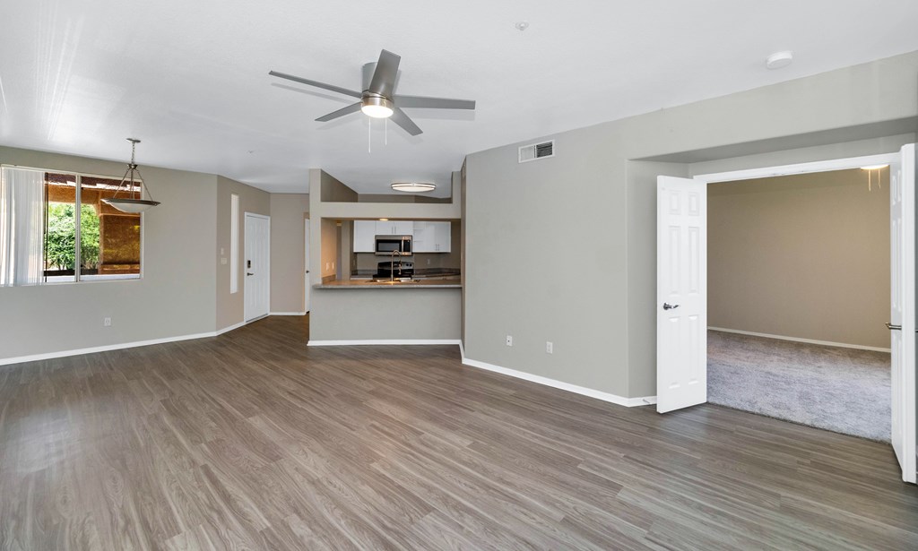 A spacious room with a ceiling fan and lighting fixtures.