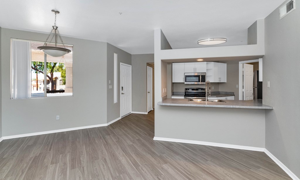 A spacious living area with a kitchen in the background.