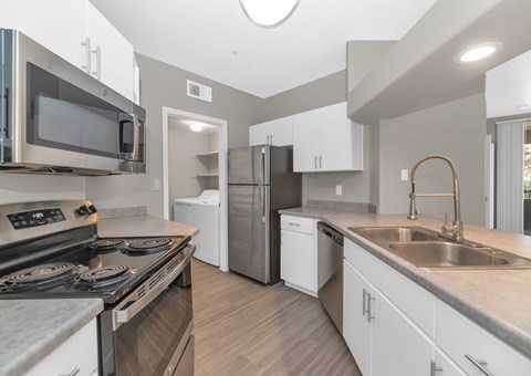 A modern kitchen with a stove top oven and a refrigerator.