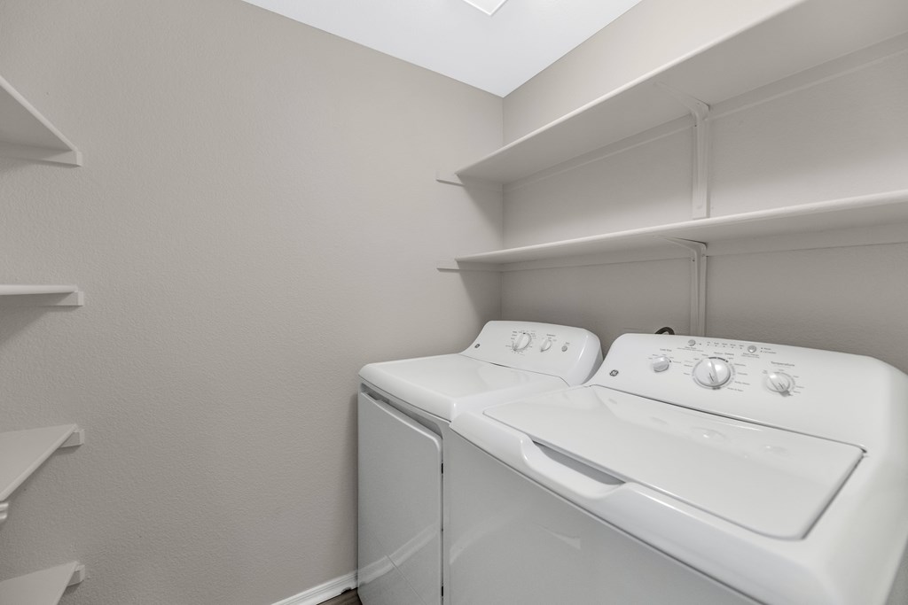 A white washing machine and dryer in a small laundry room.