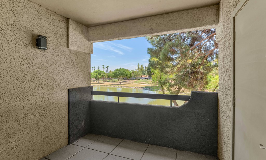 A balcony with a view of a green landscape.
