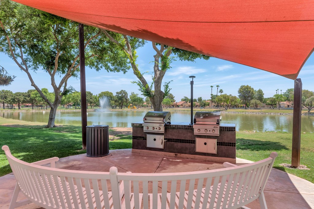 A white chair is in front of a table with a red canopy.