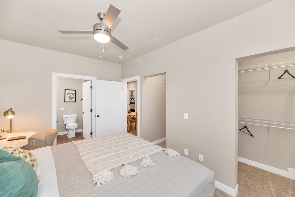 a bedroom with a large bed and a ceiling fan