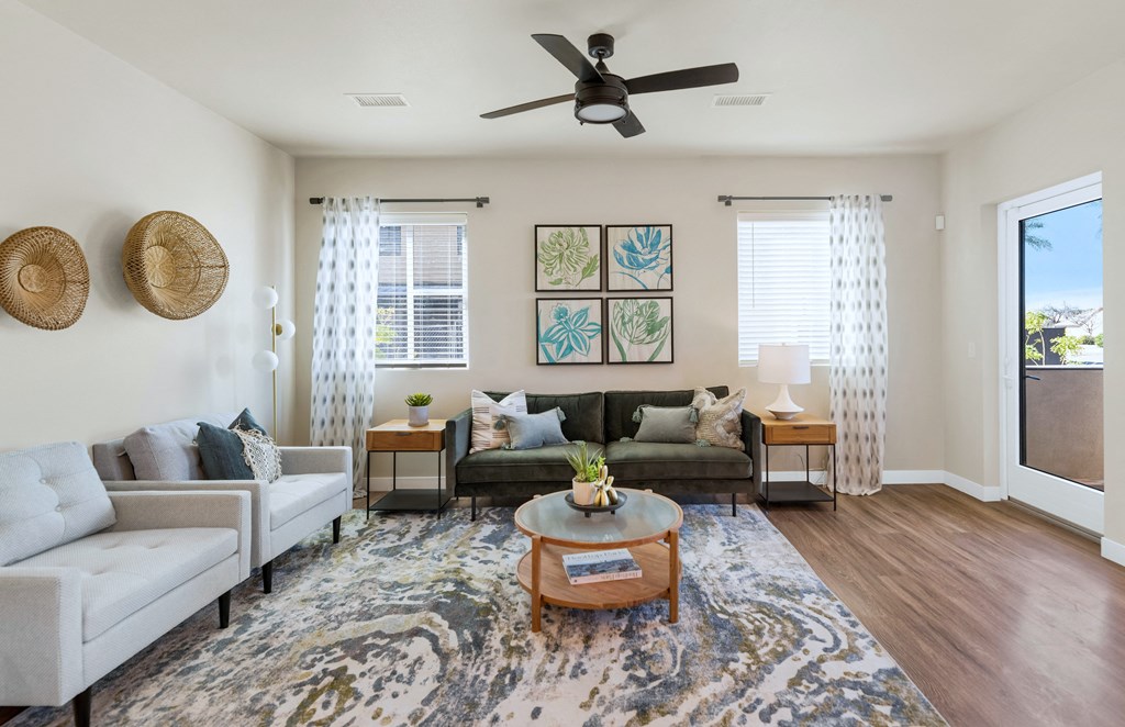 a living room with a ceiling fan and couches
