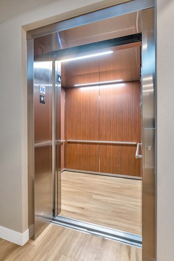 Silver elevator doors with a wooden panel inside at Solace at Ballpark Village, Goodyear, AZ, Arizona  , 85338