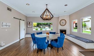 the dining room has a fireplace and a table with blue chairs