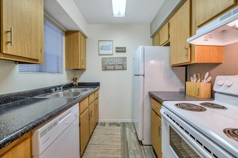 A kitchen with a white refrigerator and a stove top oven.