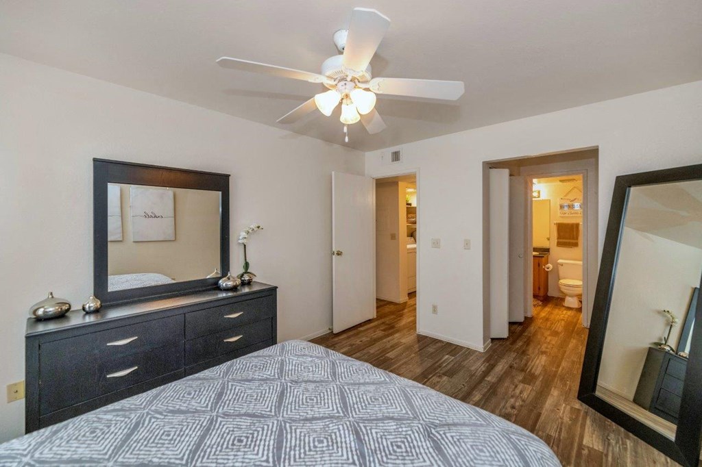 a bedroom with a large bed and a ceiling fan