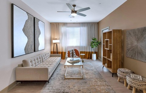 a living room filled with furniture and a ceiling fan